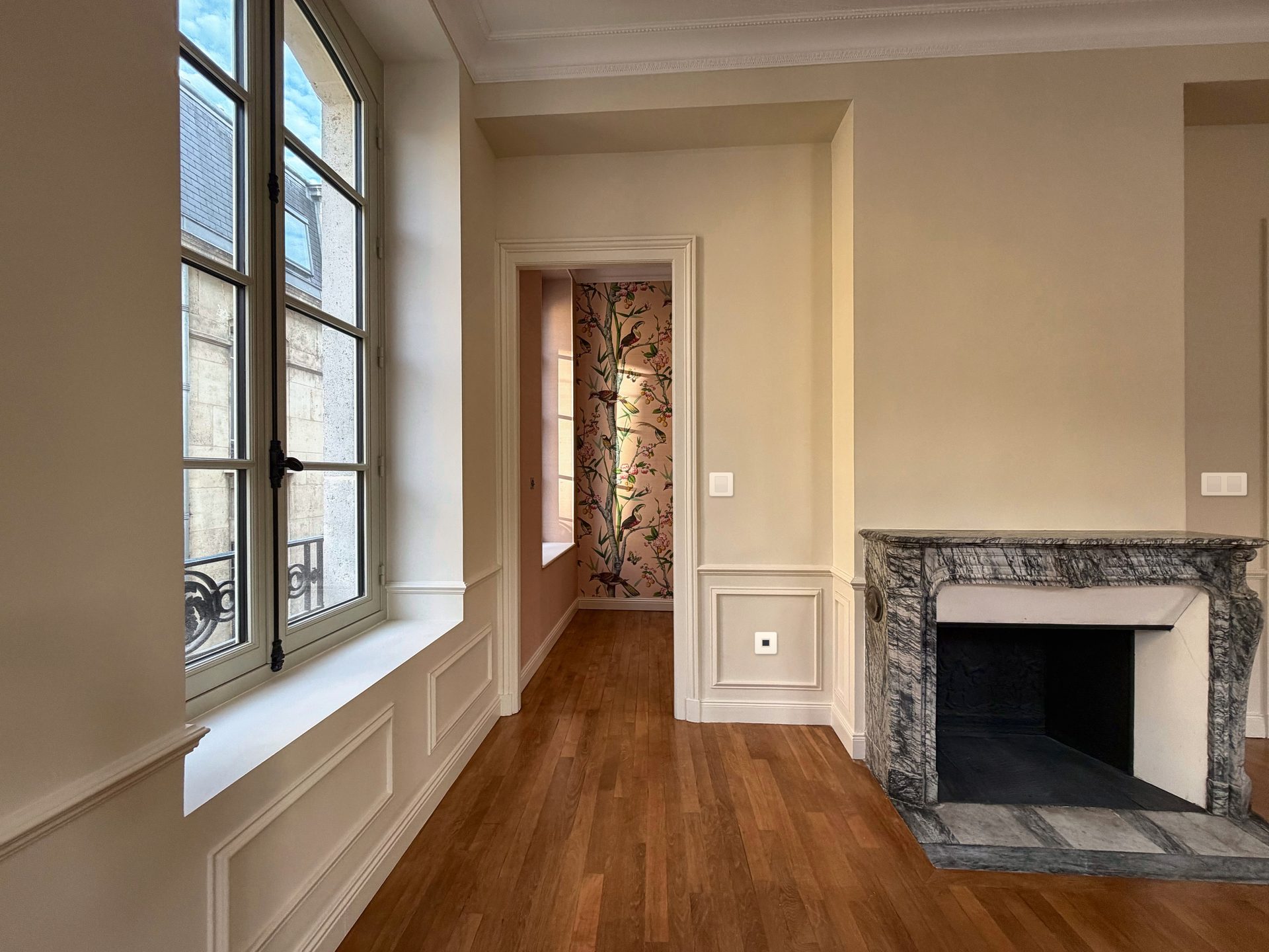Pièce rénovée avec cheminée en marbre et parquet chêne, appartement années 1920 à Reims